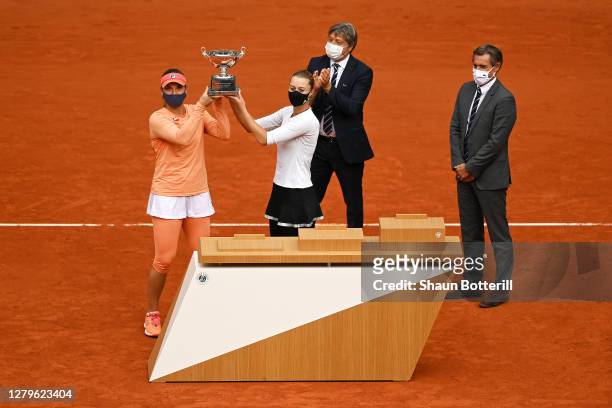 Timea Babos of Hungary and Kristina Mladenovic of France lift the winners trophy following their victory in the Women's Doubles Final against Desirae...