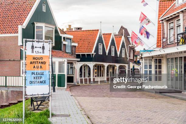 sign to keep distance during covid-19 in volendam, holland - corona landmarks stockfoto's en -beelden