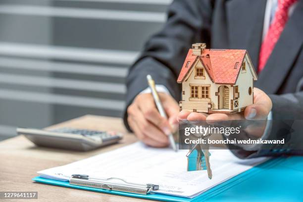 business man hand key and house model - real estate law stock pictures, royalty-free photos & images