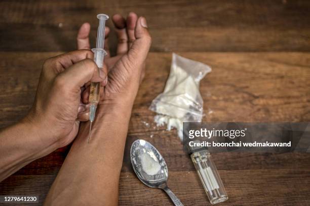 drug syringe and cooked heroin - shooting up fotografías e imágenes de stock