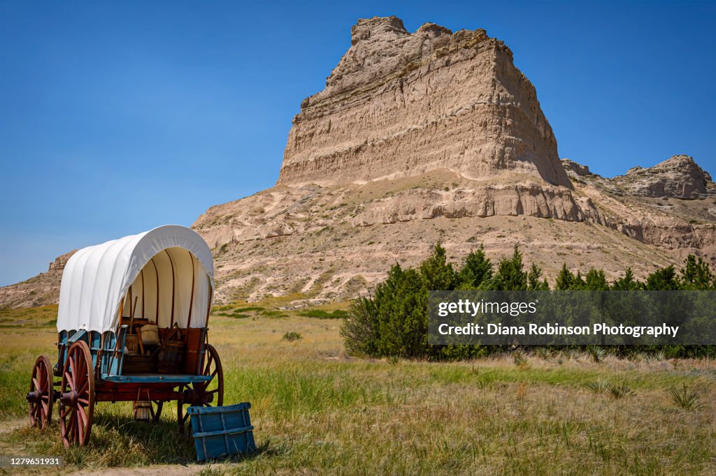 Covered wagon in front of a large butte in Scottsbluff, Nebraska