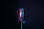 Studio microphone and pop shield on mic in the empty recording studio with copy space. Performance and show in the music business equipment.