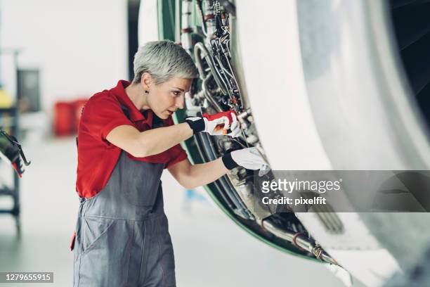 female mechanic working on airplane engine - aviation engineering imagens e fotografias de stock