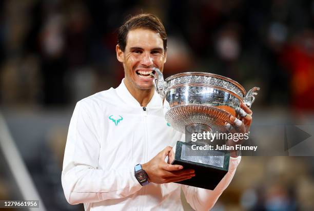 Rafael Nadal of Spain bites the winners trophy following victory in his Men's Singles Final against Novak Djokovic of Serbia on day fifteen of the...