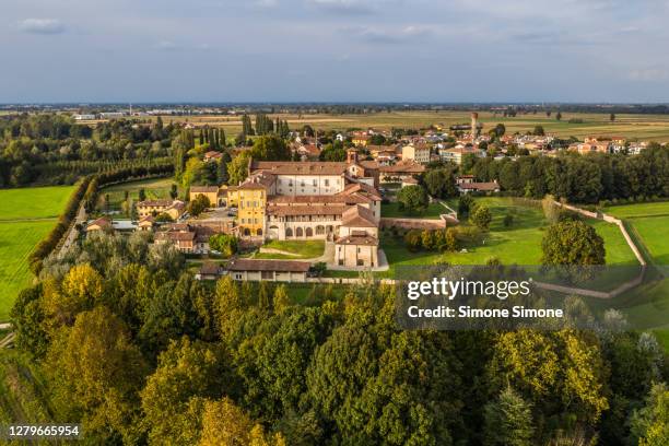 aerial view of morimondo abbey (abbazia di morimondo) at sunset in milan, italy - milan landscape stock pictures, royalty-free photos & images