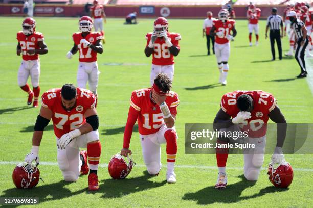 Eric Fisher, Patrick Mahomes and Kelechi Osemele of the Kansas City Chiefs kneel in the end-zone prior to the game against the Las Vegas Raiders at...