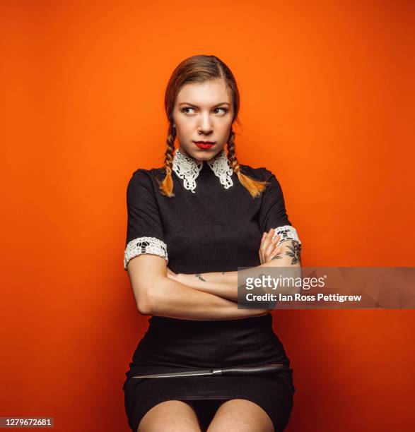 halloween - woman with black dress and pigtails with large knife - wednesday stock pictures, royalty-free photos & images