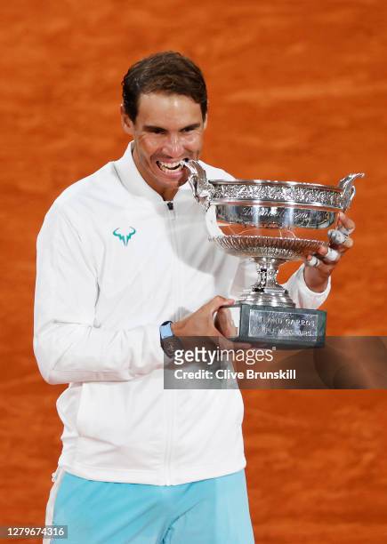 Rafael Nadal of Spain bites the winners trophy following victory in his Men's Singles Final against Novak Djokovic of Serbia on day fifteen of the...