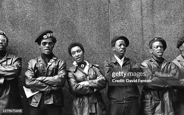 View of a line of Black Panther Party members as they demonstrate, arms folded, outside the New York County Criminal Court , New York, New York,...