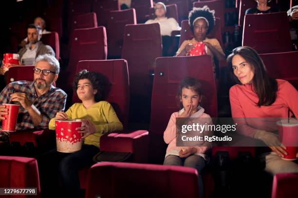 family enjoying at the movie theater - girls boys opening night stock pictures, royalty-free photos & images