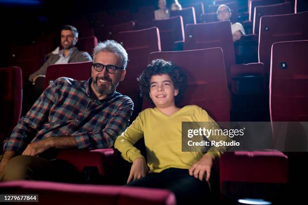 junge genießt mit großvater im kino - good boy premiere stock-fotos und bilder