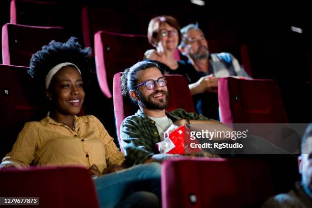 pareja viendo una película de comedia y disfrutando de su cita en el cine - lovers 2020 film fotografías e imágenes de stock