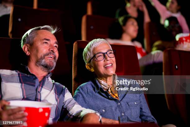 retrato de una feliz pareja de ancianos viendo una película relajante en el cine - lovers 2020 film fotografías e imágenes de stock