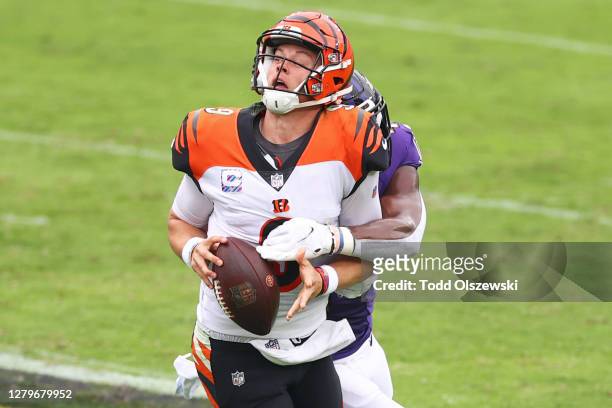 Joe Burrow of the Cincinnati Bengals is sacked by Patrick Queen of the Baltimore Ravens during the first half at M&T Bank Stadium on October 11, 2020...
