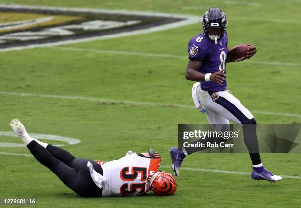 Quarterback Lamar Jackson of the Baltimore Ravens avoids the tackle of linebacker Logan Wilson of the Cincinnati Bengals in the first half at M&T...