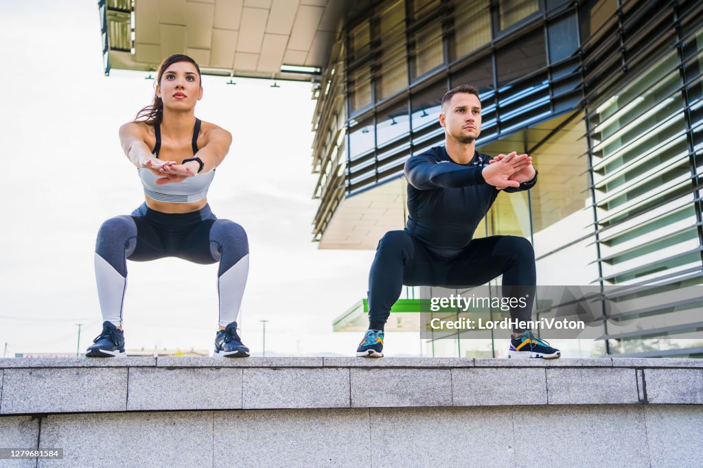 Hombre y mujer haciendo sentadillas