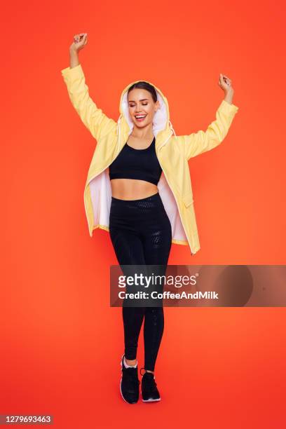 fitness dancing woman in yellow raincoat - rain model stock pictures, royalty-free photos & images