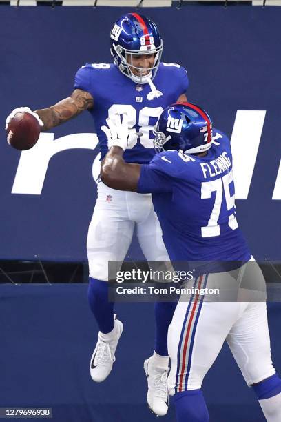Evan Engram of the New York Giants is congratulated by Cameron Fleming after scoring a touchdown against the Dallas Cowboys at AT&T Stadium on...