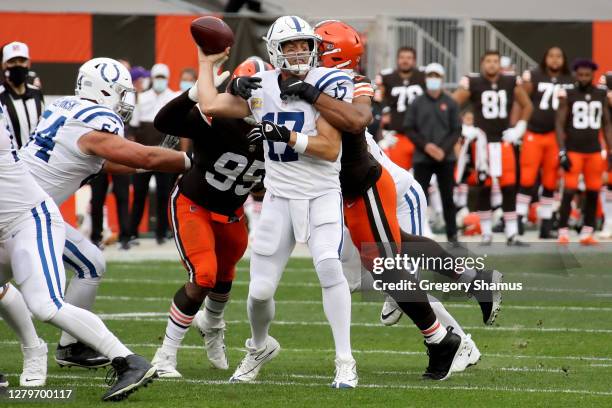 Philip Rivers of the Indianapolis Colts throws a pass while being hit by Olivier Vernon of the Cleveland Browns in the second quarter at FirstEnergy...