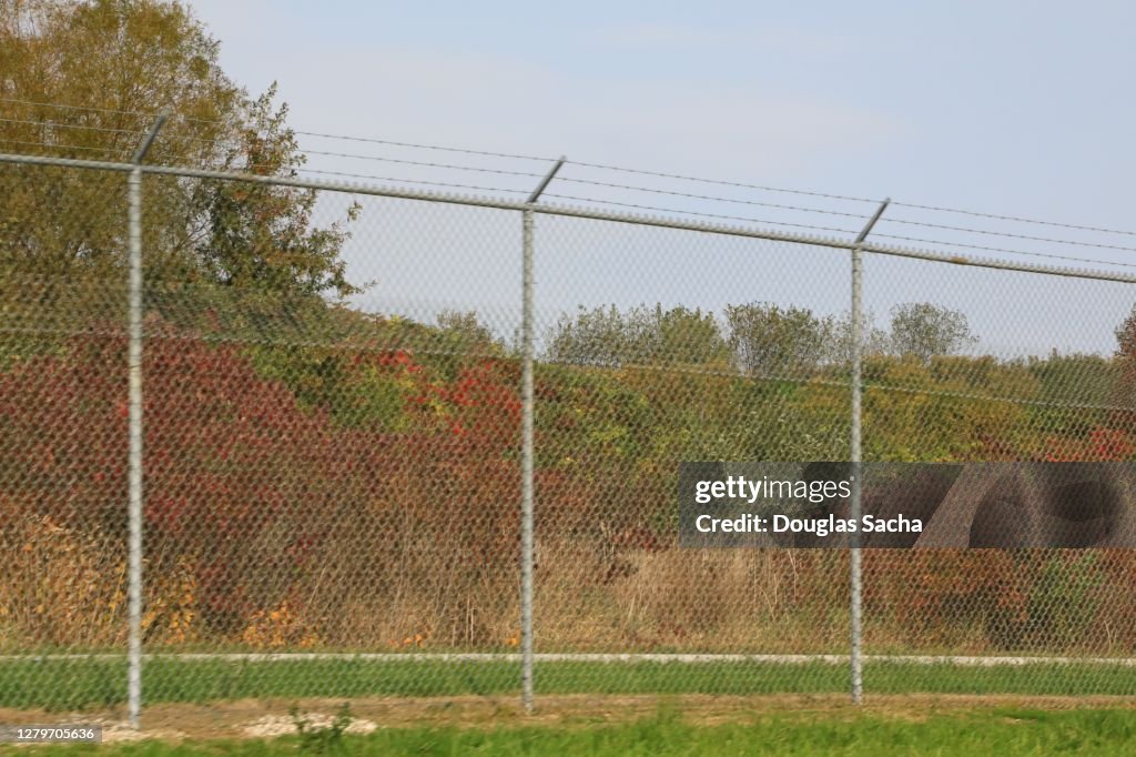 High up chain link fence with barbed wire