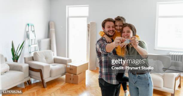 holding keys of their new home - moving house stock pictures, royalty-free photos & images