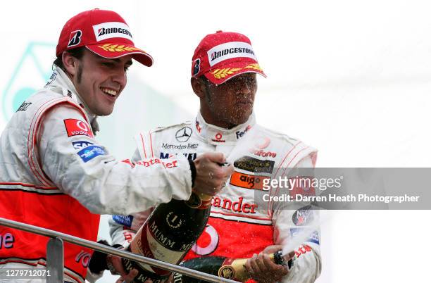 Spanish McLaren Formula One driver Fernando Alonso celebrates by spraying champagne on the winners podium winning the 2007 Malaysian Grand Prix held...