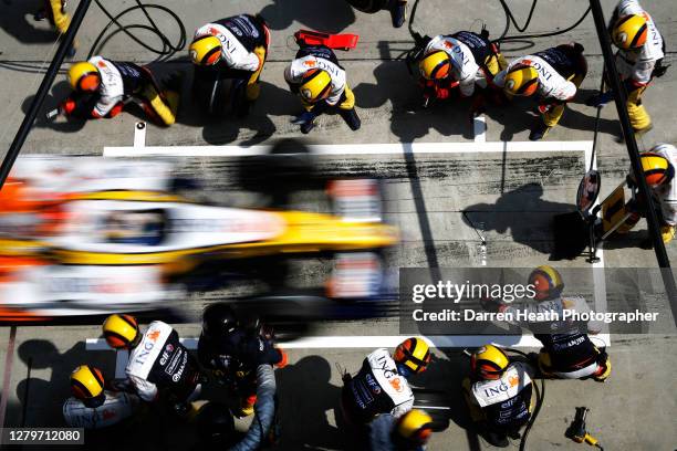 Italian Renault Formula One driver Giancarlo Fisichella in his R27 car arrives for a fuel and tyre pit stop with his Renault mechanics during the...