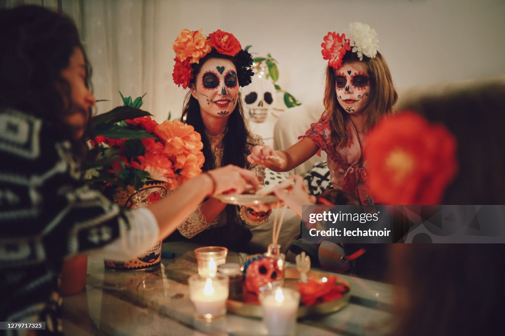 Mamá celebrando el Día de la Muerte con su hija en casa
