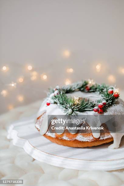 traditional christmas lemon bundt cake decorated with spruce branch and cranberrys. - christmas cake fotografías e imágenes de stock