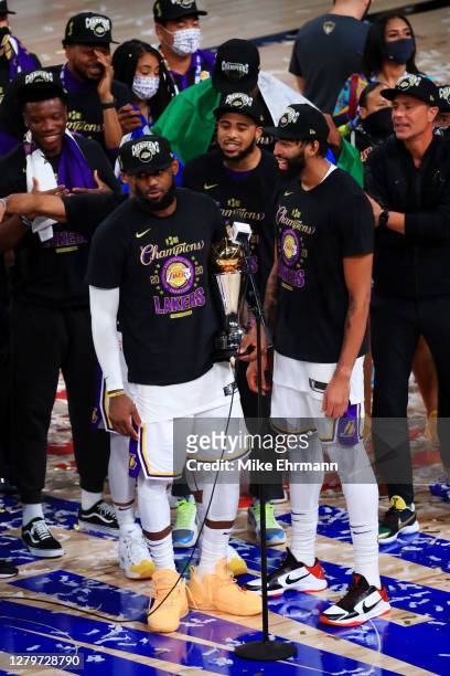 LeBron James of the Los Angeles Lakers reacts with Anthony Davis of the Los Angeles Lakers and the trophy after winning the 2020 NBA Championship...