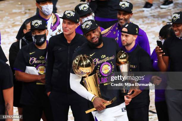 LeBron James of the Los Angeles Lakers reacts with his MVP trophy and Finals trophy after winning the 2020 NBA Championship over the Miami Heat in...