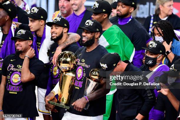 LeBron James of the Los Angeles Lakers reacts with his MVP trophy and Finals trophy after winning the 2020 NBA Championship over the Miami Heat in...