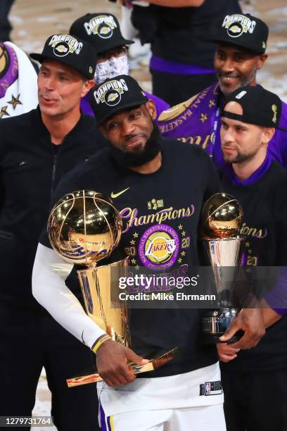 LeBron James of the Los Angeles Lakers reacts with his MVP trophy and Finals trophy after winning the 2020 NBA Championship over the Miami Heat in...