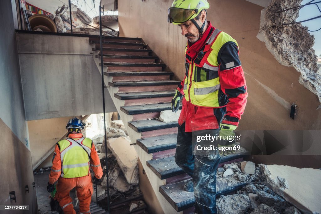 Rescuer search trough ruins of building