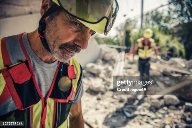 rescuer search trough ruins of building - emergency first response stock pictures, royalty-free photos & images
