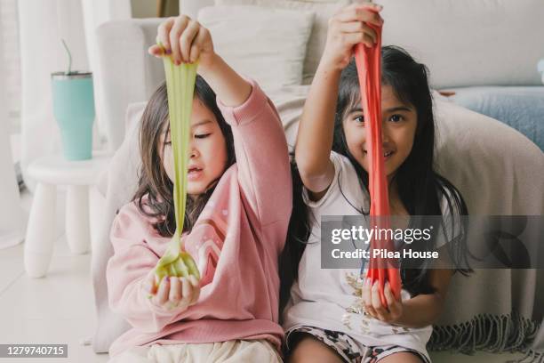 young multi-ethnic girls playing with homemade slime at home - limoso fotografías e imágenes de stock