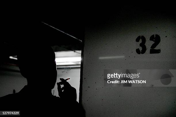 Reporter smokes a cigarette beside Column 32 on the D floor of the garage at 1401 Wilson Blvd 01 July 2005 in Rosslyn, VA, where Washington Post...