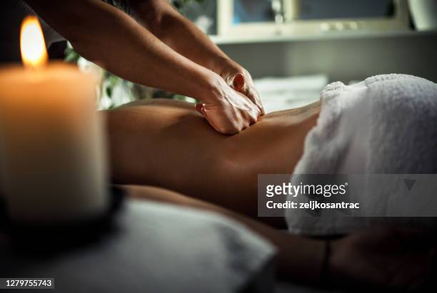 junge frau genießen therapeutische massage im spa - body massage stock-fotos und bilder