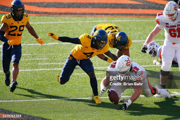 Offensive lineman Josh Sills of the Oklahoma State Cowboys recovers a fumble by running back Chuba Hubbard against cornerback Alonzo Addae and...