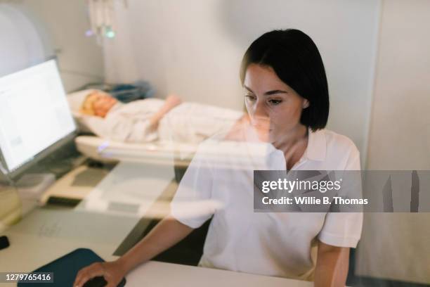 patient reflected in window while mri technician works at computer - mouse pad stock-fotos und bilder