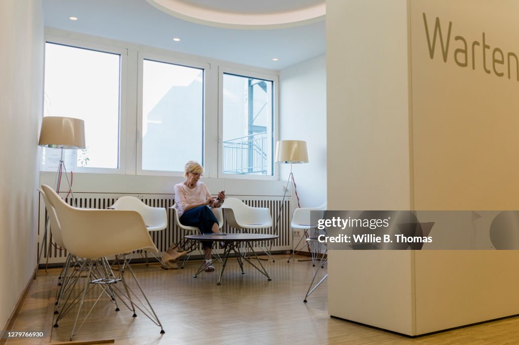 Mature Woman Sitting In MRI Clinic Waiting Room