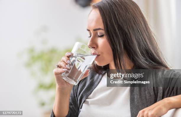 female drinks water from a glass. - sedento - fotografias e filmes do acervo