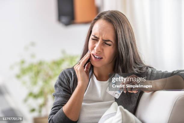intensive toothache of a woman holding pills blister. - dor de dentes imagens e fotografias de stock