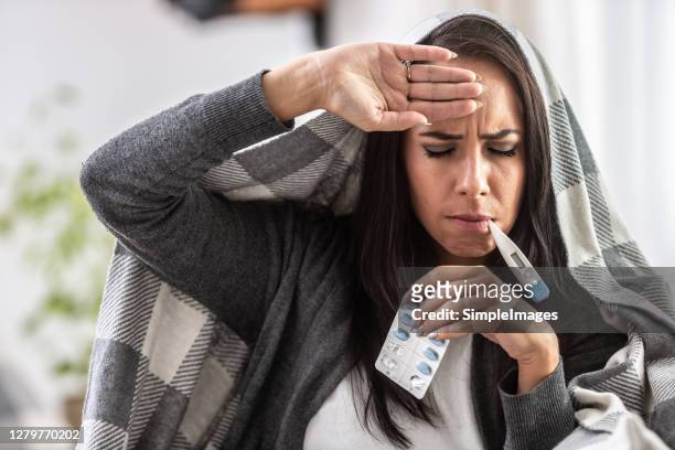 fever and flu having girl with thermometer and pills. - caucasian woman sick in bed coughing stock pictures, royalty-free photos & images