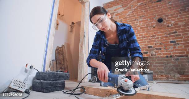 zelfvoorzienende vrouw die het werk van mannen in nieuw flat doet - slijptol stockfoto's en -beelden