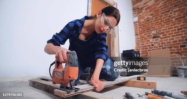 self-sufficient woman doing men's work in new apartment - safety glasses at home stock pictures, royalty-free photos & images