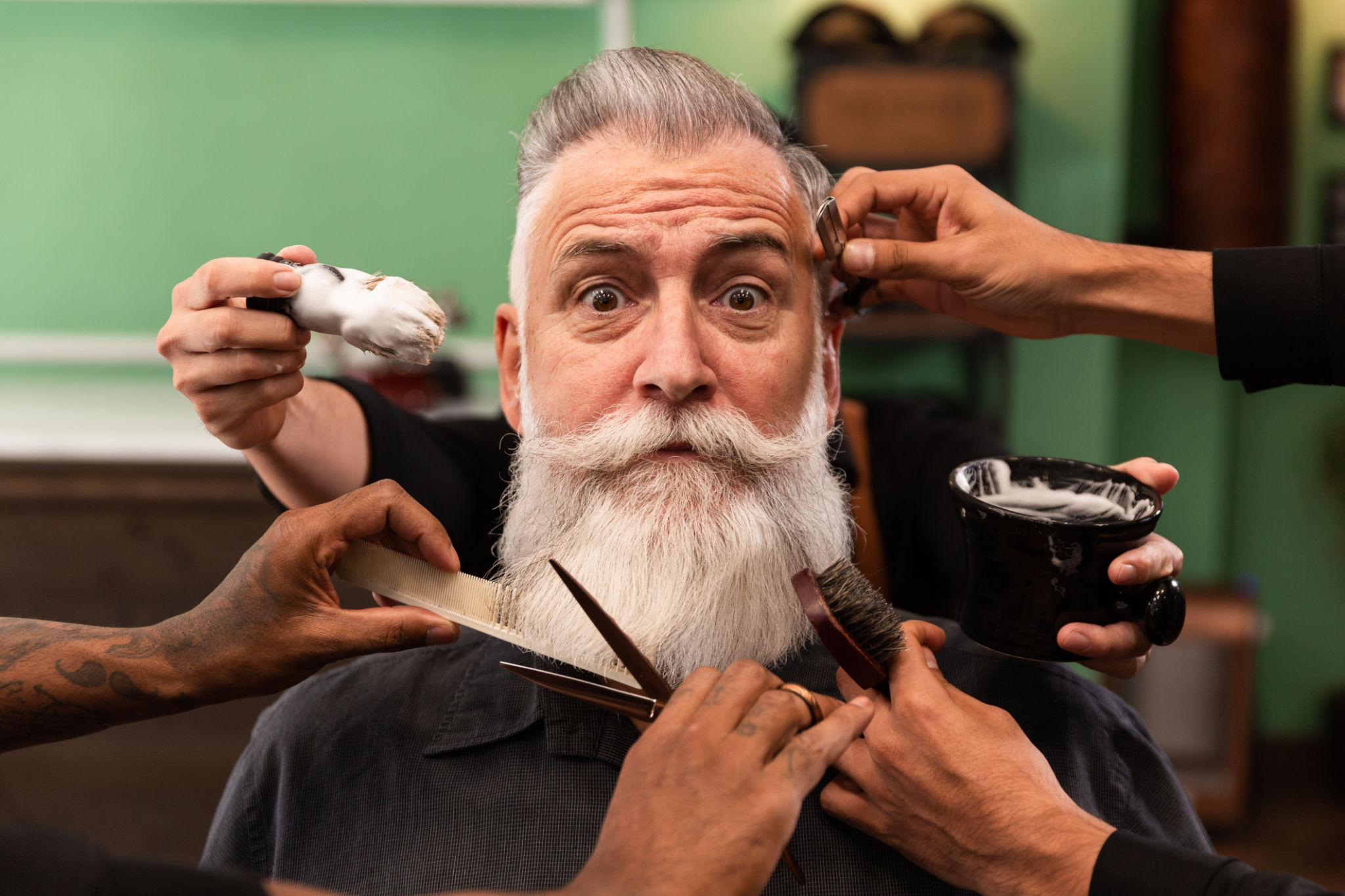 homem com barba branca na barbearia com mãos de barbeiro com instrumentos de corte e barbear homem com barba branca na barbearia com mãos de barbeiro com instrumentos de corte e barbear