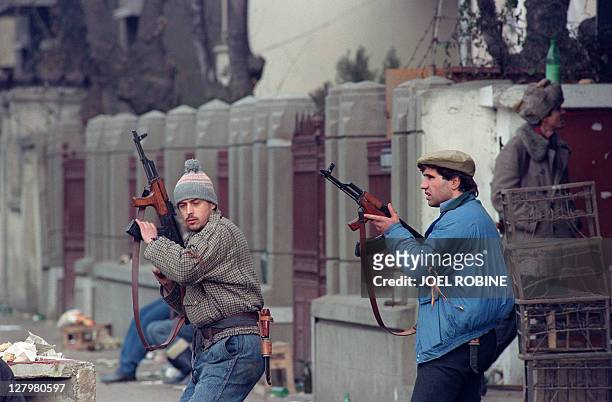 Anti-Communist Romanian civilians fight together on December 24, 1989 in downtown Bucharest as they return fire against the supposedly Securitate...