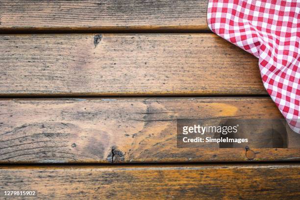 wooden surface background with a partial view of checkered cloth. - white table top stock pictures, royalty-free photos & images