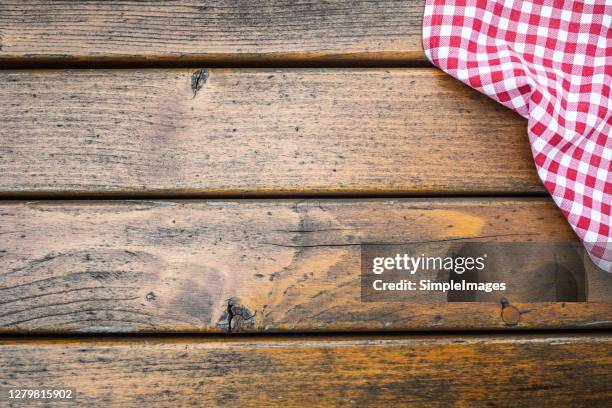 wooden surface background with a partial view of checkered cloth. - table top imagens e fotografias de stock